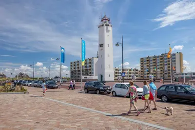a group of people walking in front of a lighthouse at Noordwijk Holiday Rentals in Noordwijk