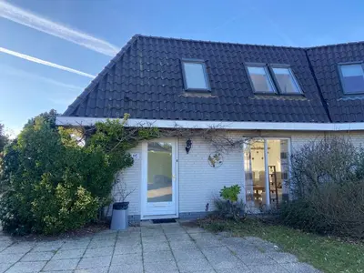 a white house with a black roof at Noordwijk Holiday Rentals in Noordwijk