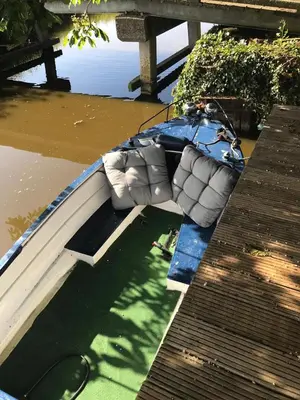 a boat sitting in the water next to a dock at Paleis Noordeinde in Grootschermer