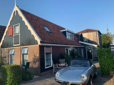a blue car parked in front of a house at Paleis Noordeinde in Grootschermer
