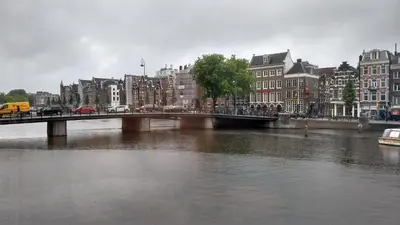 a bridge over a river in a city with buildings at Rembrandt Square Boat in Amsterdam