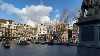a city square with buildings and a statue in the foreground at Rembrandt Square Boat in Amsterdam
