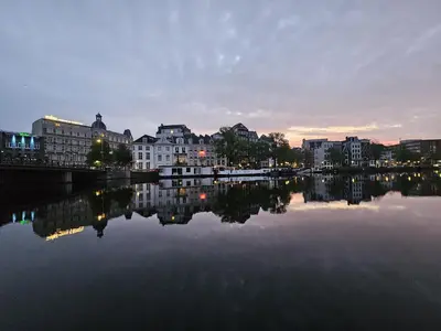 a view of a river with buildings and a city at Rembrandt Square Boat in Amsterdam