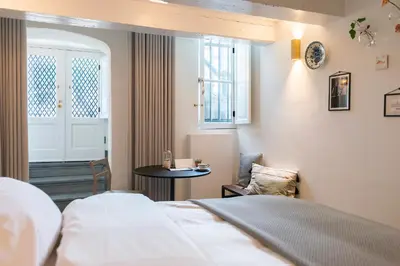 a hotel room with a bed and a table at Milkhouse Luxury Stay Amsterdam in Amsterdam
