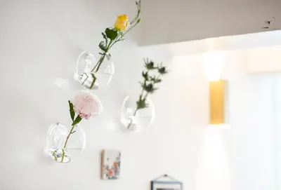 a group of vases with flowers in them on a wall at Milkhouse Luxury Stay Amsterdam in Amsterdam