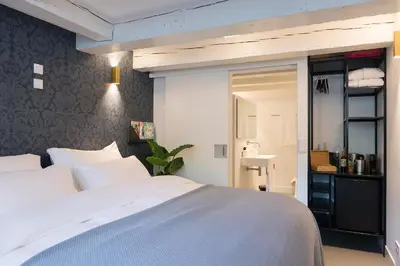 a bedroom with a large white bed and a mirror at Milkhouse Luxury Stay Amsterdam in Amsterdam