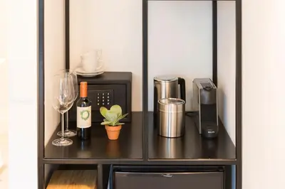 a black cabinet with a microwave and a bottle of wine at Milkhouse Luxury Stay Amsterdam in Amsterdam