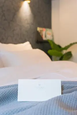 a white sign sitting on top of a bed at Milkhouse Luxury Stay Amsterdam in Amsterdam