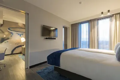 a hotel room with a large bed and a tv at Postillion Hotel Amsterdam in Amsterdam