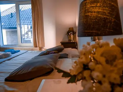 a bedroom with a bed with pillows and a window at Hotel / Pension Villa Tanahlot in Zandvoort