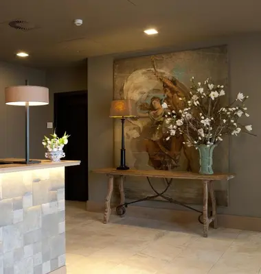a vase of flowers on a table next to a painting at Fletcher Hotel - Restaurant Nautisch Kwartier in Huizen