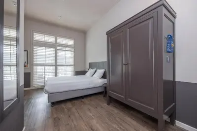 a bedroom with a bed and a large closet at Fletcher Hotel - Restaurant Nautisch Kwartier in Huizen