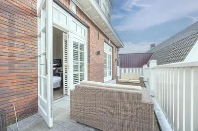 a balcony of a brick building with a bench at Fletcher Hotel - Restaurant Nautisch Kwartier in Huizen