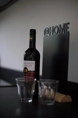 a bottle of wine sitting on a table with two glasses at At the Dunes in Egmond aan den Hoef