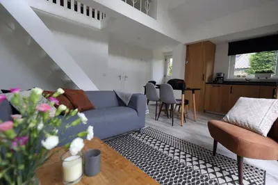 a living room with a couch and a table at At the Dunes in Egmond aan den Hoef