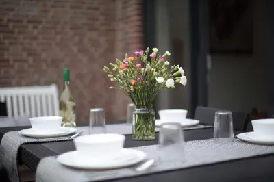 a table with a vase of flowers on it at At the Dunes in Egmond aan den Hoef