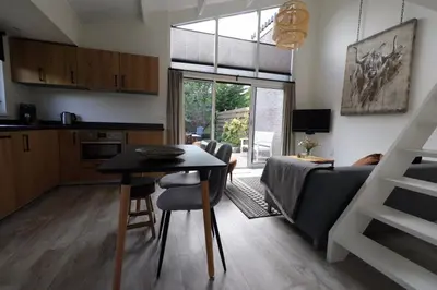 a kitchen and living room with a table and a couch at At the Dunes in Egmond aan den Hoef