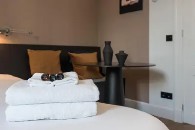 a pile of towels sitting on a bed with a table at City centre studio canal belt in Amsterdam