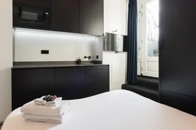 a bedroom with a white bed and a sink at City centre studio canal belt in Amsterdam
