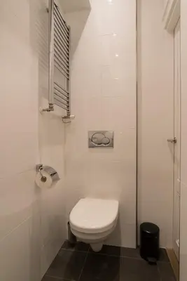 a white bathroom with a toilet and a window at City centre studio canal belt in Amsterdam