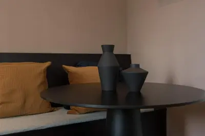 a table with a vase on top of it next to a bed at City centre studio canal belt in Amsterdam