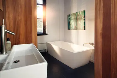 a bathroom with a white tub and a sink at HUISJES AAN DE AMSTEL - Your home away from home in Amstelveen
