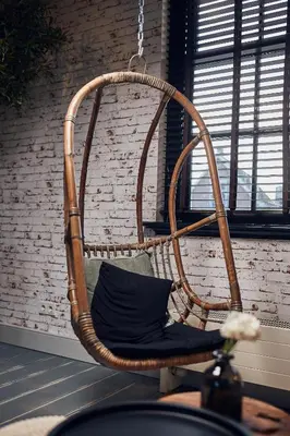 a wicker chair in front of a brick wall at HUISJES AAN DE AMSTEL - Your home away from home in Amstelveen