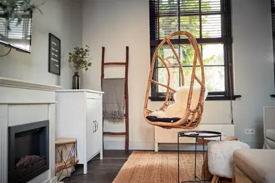 a living room with a chair and a fireplace at HUISJES AAN DE AMSTEL - Your home away from home in Amstelveen
