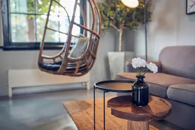 a living room with a vase of flowers on a table at HUISJES AAN DE AMSTEL - Your home away from home in Amstelveen