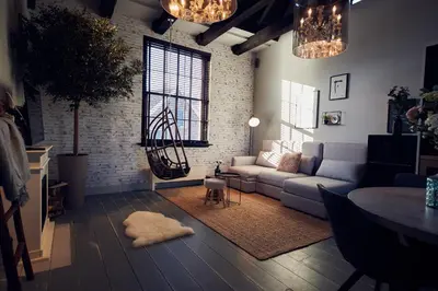 a living room with a couch and a brick wall at HUISJES AAN DE AMSTEL - Your home away from home in Amstelveen