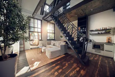 a living room with a white couch and a staircase at HUISJES AAN DE AMSTEL - Your home away from home in Amstelveen