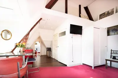 a living room with a red rug and white walls at Xaviera's Bed and Breakfast in Amsterdam