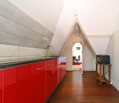 a kitchen with red cabinets and an attic at Xaviera's Bed and Breakfast in Amsterdam