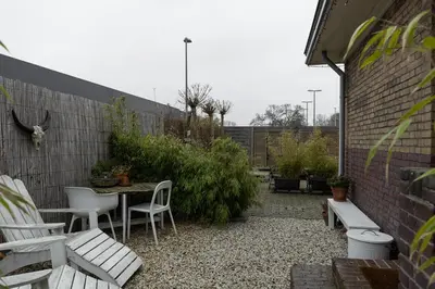 a patio with a table and chairs and a brick wall at De oude slaght- luxe suite met buitensauna in Zaandam