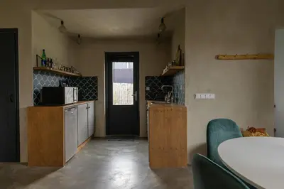 a kitchen with a table and a door in a room at De oude slaght- luxe suite met buitensauna in Zaandam