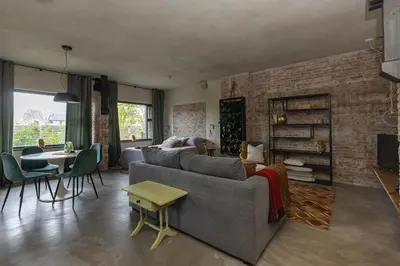 a living room with a couch and a brick wall at De oude slaght- luxe suite met buitensauna in Zaandam