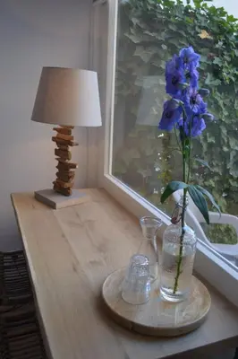 a table with a vase with purple flowers on it at Behind the Beach in Zandvoort