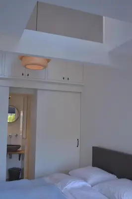 a bedroom with a white bed and a white ceiling at Behind the Beach in Zandvoort