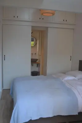 a bedroom with a white bed and a mirror at Behind the Beach in Zandvoort