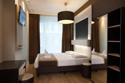 a bedroom with two beds and a large window at Hotel Mosaic City Centre in Amsterdam