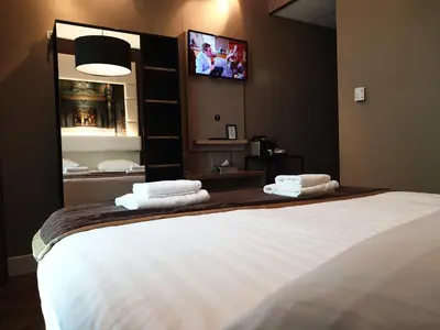 a bedroom with a bed with a tv on the wall at Hotel Mosaic City Centre in Amsterdam
