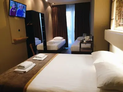 a hotel room with two beds and a tv at Hotel Mosaic City Centre in Amsterdam