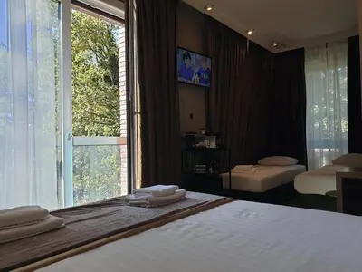 a bedroom with a bed and a large window at Hotel Mosaic City Centre in Amsterdam