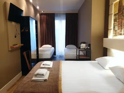 a hotel room with a large bed with towels on it at Hotel Mosaic City Centre in Amsterdam