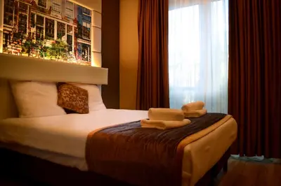 a hotel room with a bed with towels on it at Hotel Mosaic City Centre in Amsterdam