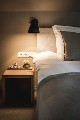 a bedroom with a bed and a nightstand with a lamp at Boutique Hotel Villa Kranenbergh in Bergen