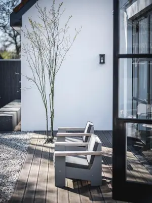 a bench sitting on a deck next to a tree at Boutique Hotel Villa Kranenbergh in Bergen