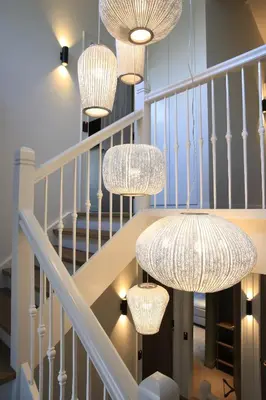 a staircase with chandeliers hanging from the ceiling at Boutique Hotel Villa Kranenbergh in Bergen
