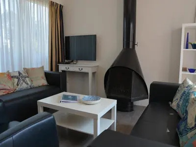 a living room with a couch and a fireplace at Bungalow in Noordwijk near Lake & Beach in Noordwijkerhout