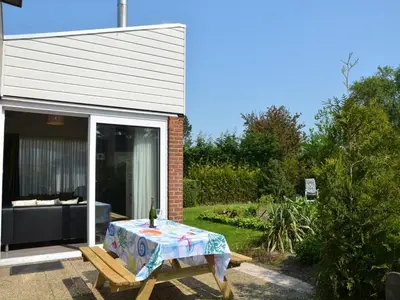 a table with a table cloth on it in front of a house at Bungalow in Noordwijk near Lake & Beach in Noordwijkerhout